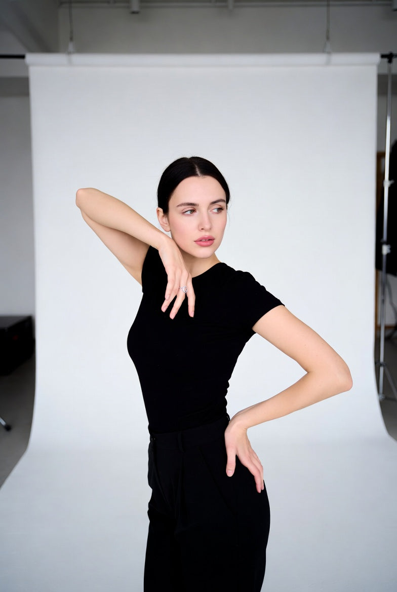 Mujer con atuendo minimalista negro, pose elegante y atemporal