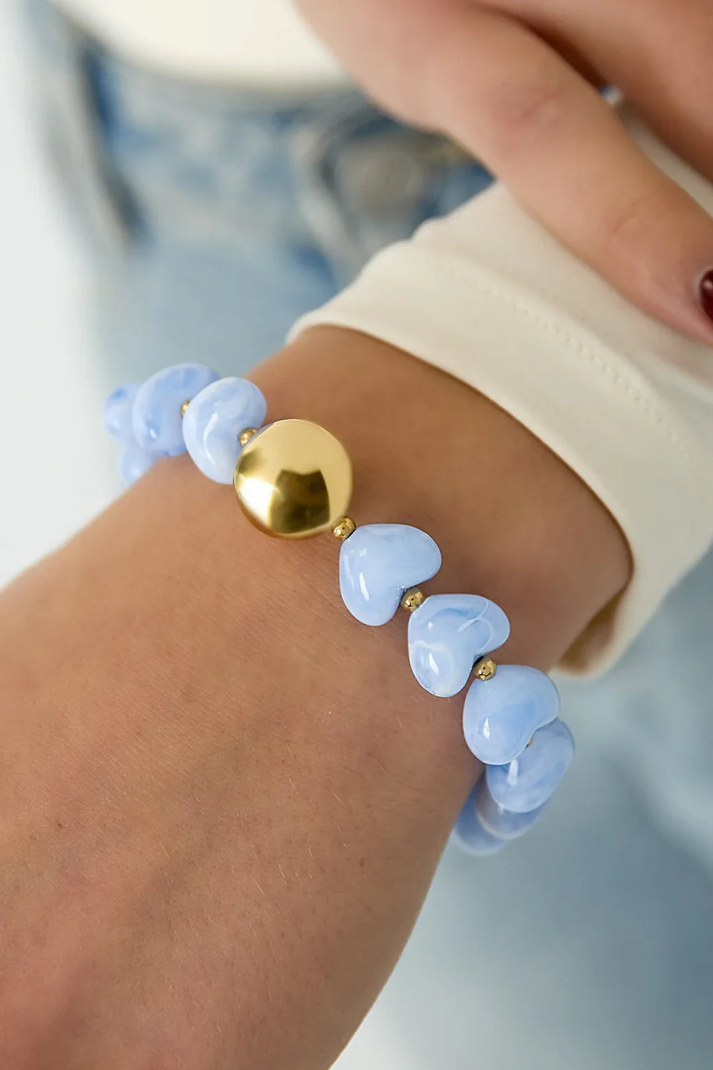 Pulsera con corazones azules y esfera dorada, diseño minimalista y atemporal